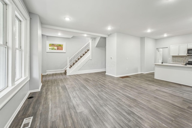 392 Morrison Ave, Columbus, OH 43205 - unfurnished living room featuring stairway, dark wood-type flooring, baseboards, and recessed lighting