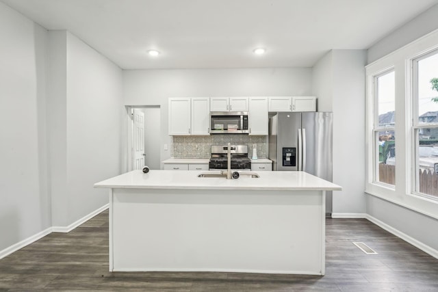 392 Morrison Ave, Columbus, OH 43205 - kitchen with stainless steel appliances, backsplash, dark wood-type flooring, a kitchen island with sink, and white cabinets