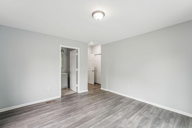 392 Morrison Ave, Columbus, OH 43205 - unfurnished bedroom with wood finished floors, baseboards, ensuite bath, and a closet