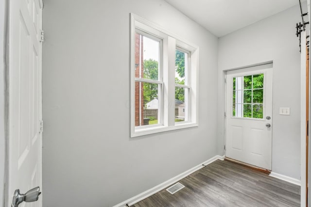 392 Morrison Ave, Columbus, OH 43205 - doorway with baseboards, a barn door, and dark wood-style floors