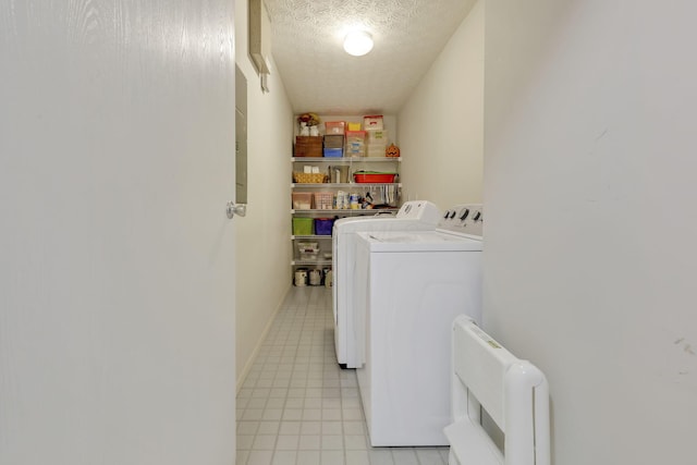 washroom featuring radiator heating unit, washing machine and clothes dryer, and a textured ceiling