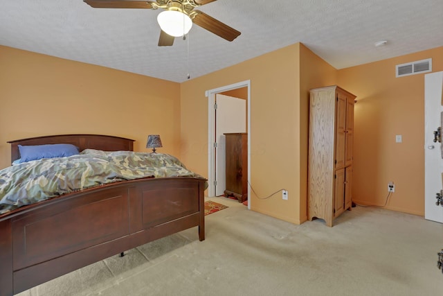 bedroom featuring light carpet, a textured ceiling, and ceiling fan