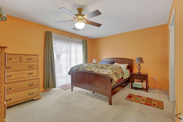 bedroom with light colored carpet, a textured ceiling, and ceiling fan