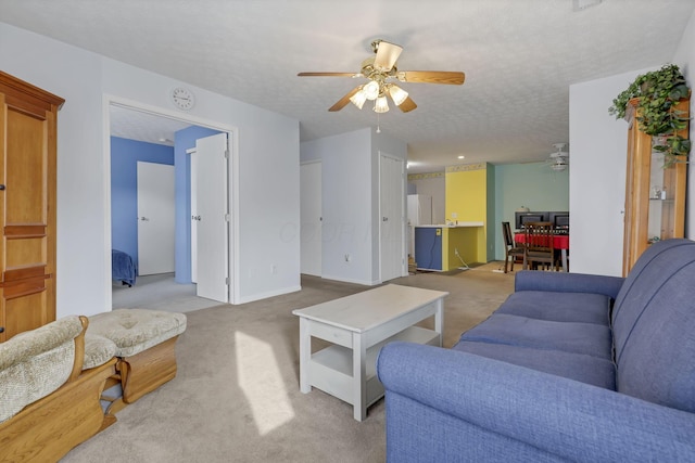 carpeted living room featuring ceiling fan and a textured ceiling