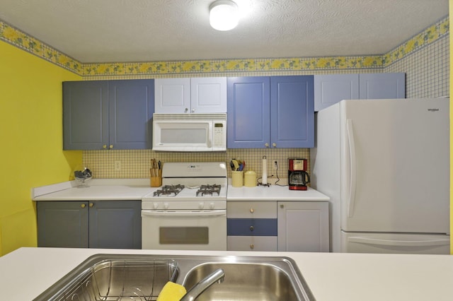 kitchen with tasteful backsplash, white appliances, sink, and a textured ceiling