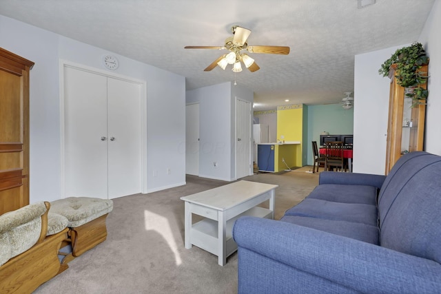 carpeted living room with ceiling fan and a textured ceiling