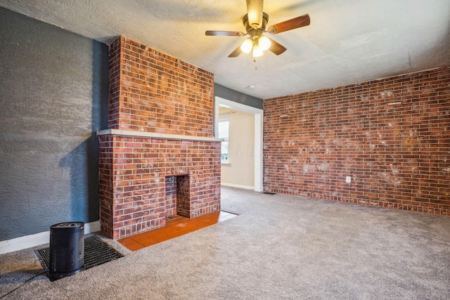 unfurnished living room with brick wall, a fireplace, light colored carpet, ceiling fan, and a textured ceiling