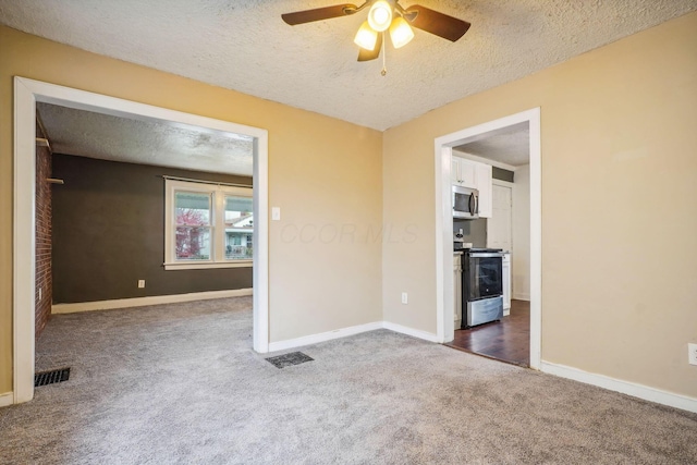 carpeted empty room with ceiling fan and a textured ceiling