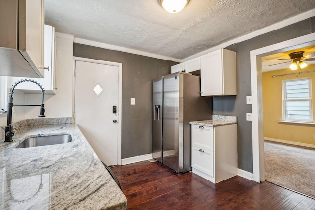 kitchen with light stone countertops, sink, and stainless steel fridge with ice dispenser