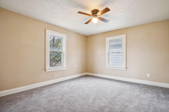 carpeted spare room with a textured ceiling and ceiling fan