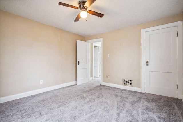 carpeted spare room with ceiling fan and a textured ceiling