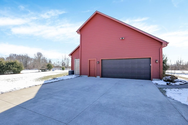 view of side of property featuring a garage and central AC unit