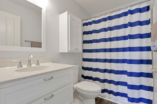 bathroom featuring hardwood / wood-style flooring, vanity, walk in shower, toilet, and a textured ceiling