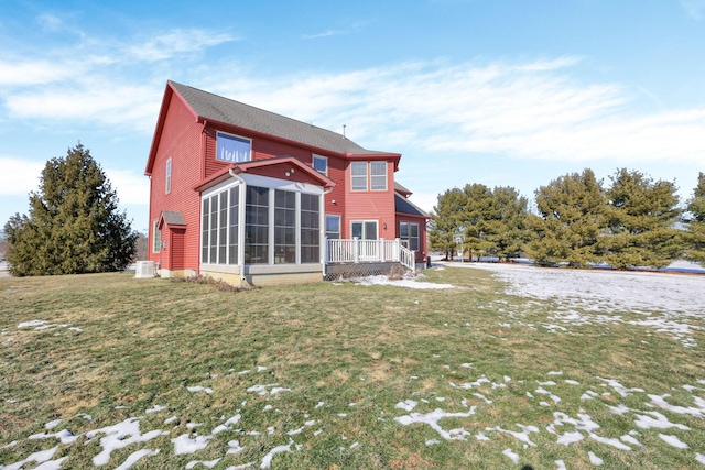 rear view of house with a yard and a sunroom