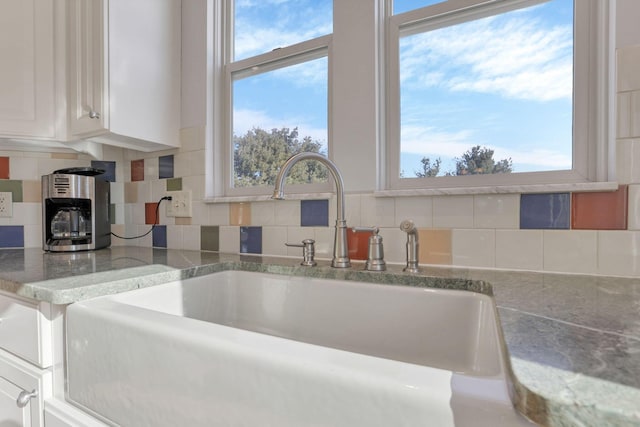 kitchen with white cabinetry, sink, decorative backsplash, and a wealth of natural light