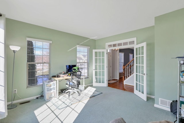 carpeted home office with french doors