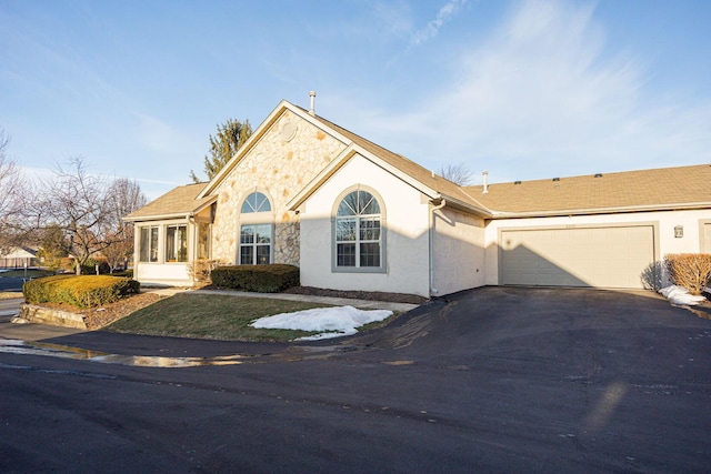 view of front of home with a garage and a sunroom