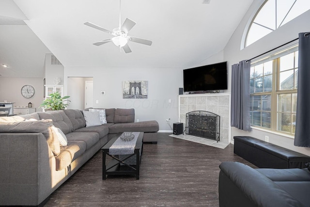 living room featuring a tile fireplace, high vaulted ceiling, dark wood-type flooring, and ceiling fan