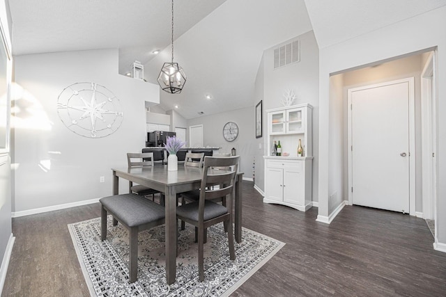 dining area featuring high vaulted ceiling, dark hardwood / wood-style floors, and a chandelier