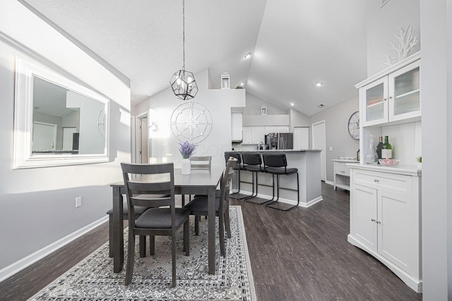 dining space with vaulted ceiling, dark hardwood / wood-style floors, and an inviting chandelier