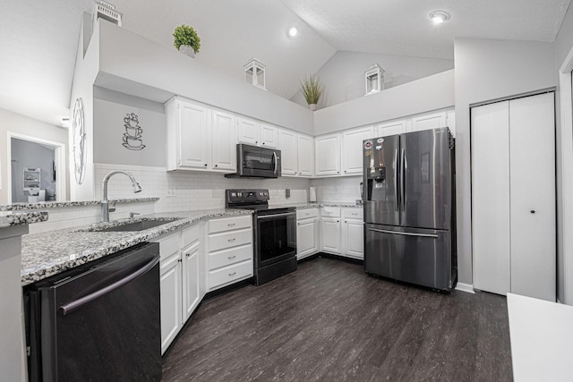 kitchen featuring sink, white cabinets, light stone counters, and black appliances