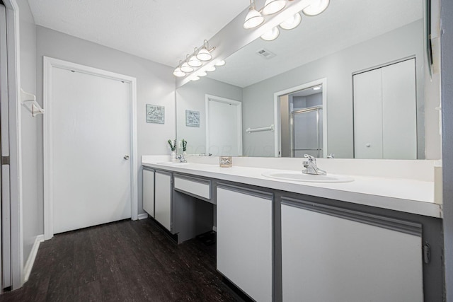 bathroom with vanity, wood-type flooring, and a shower with door