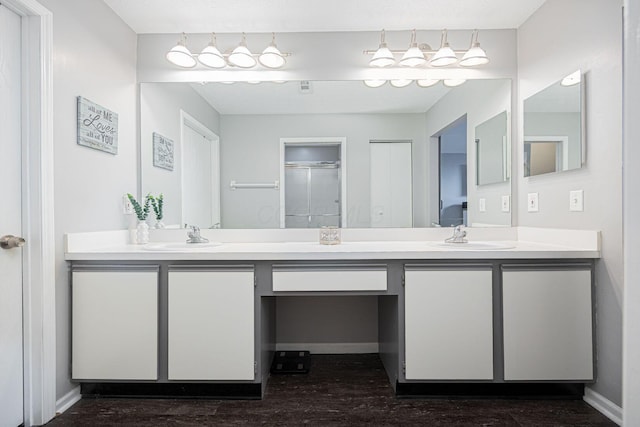 bathroom with walk in shower, vanity, and wood-type flooring