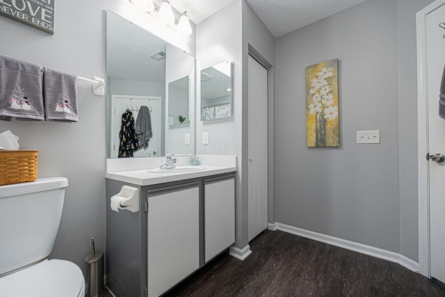 bathroom featuring vanity, toilet, wood-type flooring, and a textured ceiling