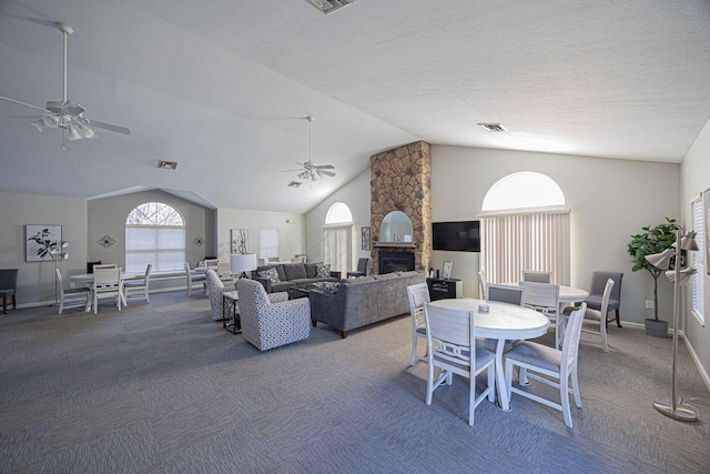 dining space featuring a stone fireplace, high vaulted ceiling, ceiling fan, and carpet flooring