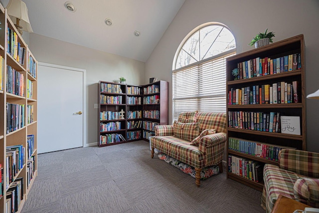 sitting room with high vaulted ceiling and carpet flooring