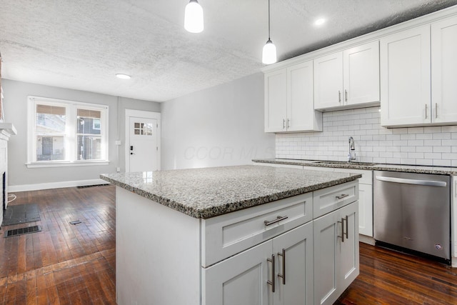 kitchen featuring white cabinetry, stainless steel dishwasher, light stone countertops, and hanging light fixtures