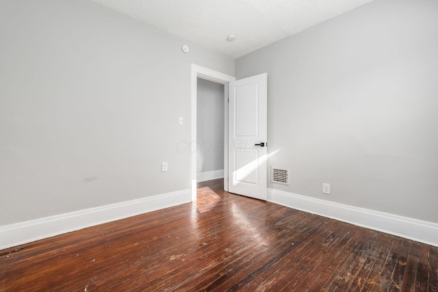 empty room featuring hardwood / wood-style flooring and a textured ceiling