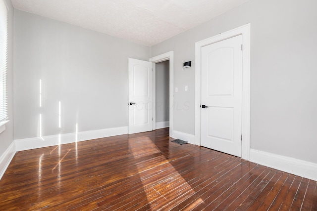 unfurnished room featuring hardwood / wood-style floors and a textured ceiling