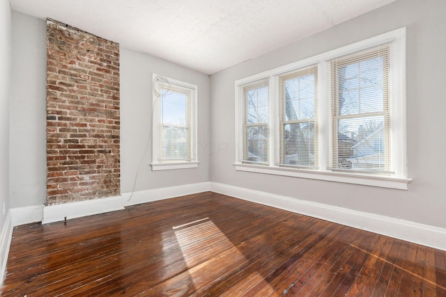 unfurnished room featuring wood-type flooring, a textured ceiling, and a wealth of natural light