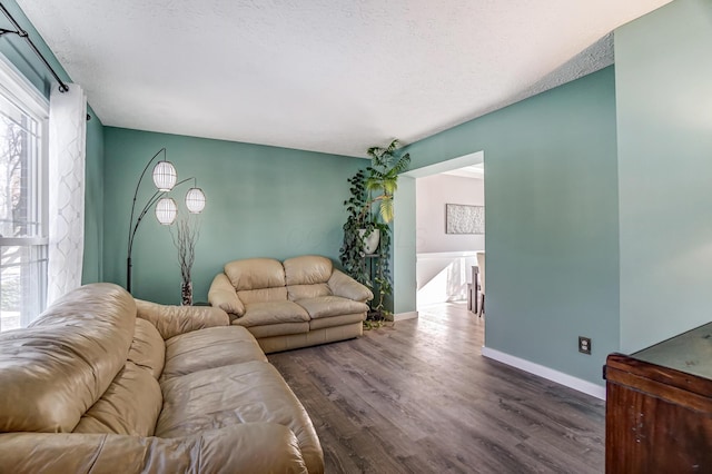 living room featuring plenty of natural light, a textured ceiling, and dark hardwood / wood-style flooring