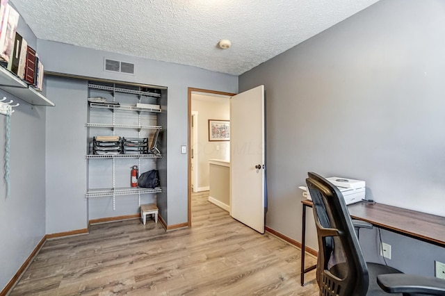 office space with light hardwood / wood-style flooring and a textured ceiling