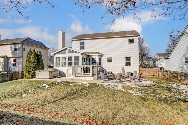 back of house featuring a hot tub, a patio, a yard, and an outdoor fire pit