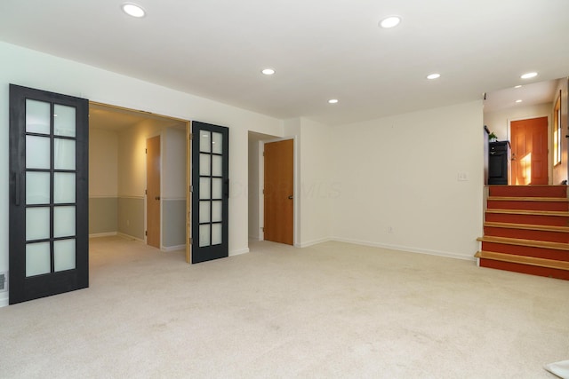 carpeted spare room featuring french doors