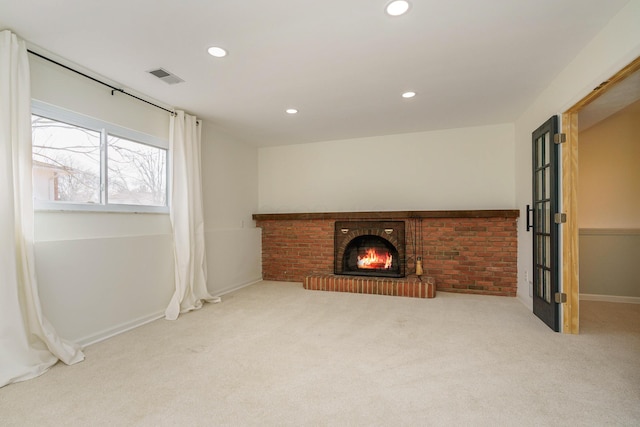 unfurnished living room with light colored carpet and a fireplace