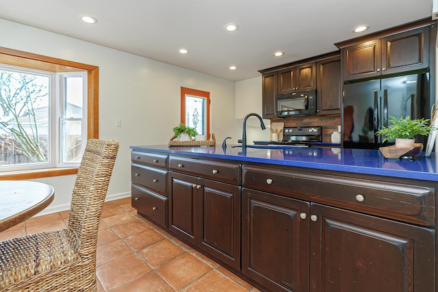 kitchen with light tile patterned flooring, sink, dark brown cabinets, and black appliances