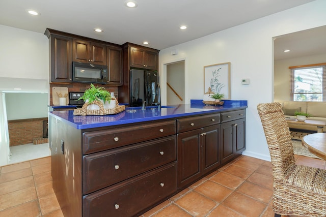 kitchen with dark brown cabinetry, sink, black appliances, and light tile patterned flooring