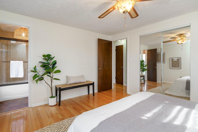 bedroom with ceiling fan, hardwood / wood-style flooring, and a textured ceiling