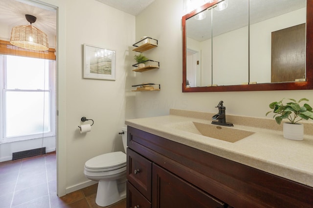 bathroom with vanity, plenty of natural light, tile patterned floors, and toilet