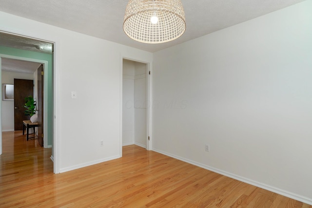 empty room featuring light hardwood / wood-style flooring and a textured ceiling