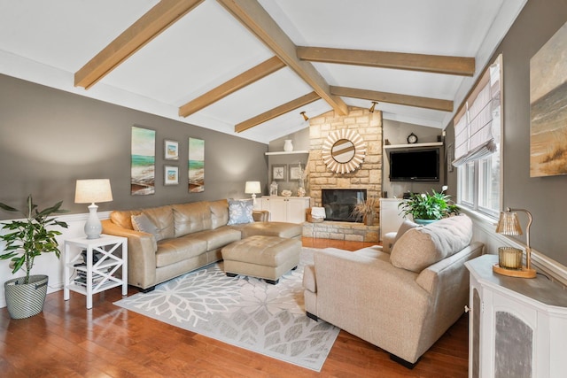 living room featuring lofted ceiling with beams, wood-type flooring, and a fireplace