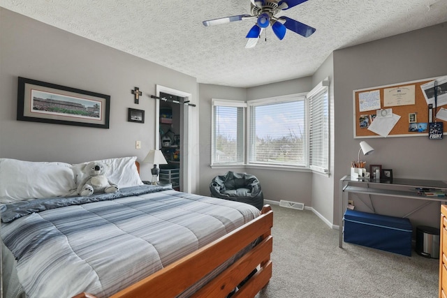 bedroom with light colored carpet, a textured ceiling, and ceiling fan