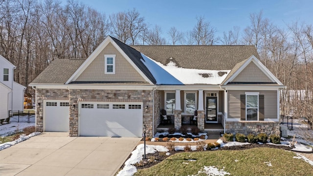 craftsman inspired home with a garage and covered porch