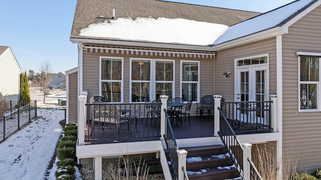 snow covered deck featuring french doors