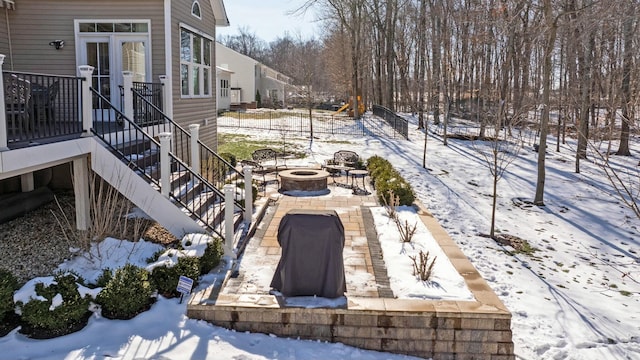 snow covered patio featuring a fire pit