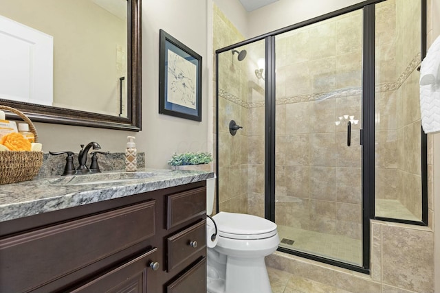 bathroom with tile patterned floors, vanity, toilet, and an enclosed shower